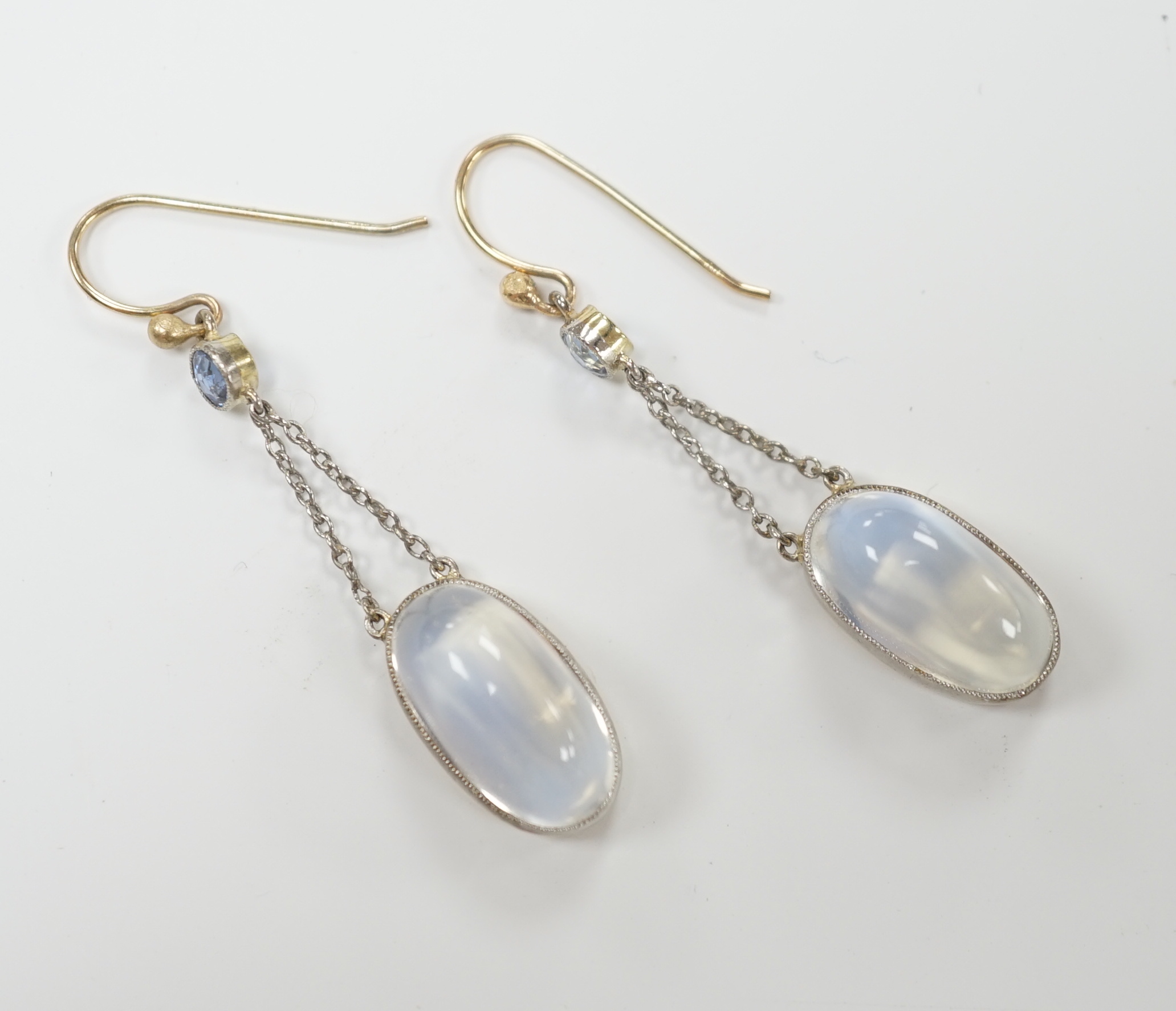 A pair of yellow metal, oval cabochon moonstone and round cut sapphire set drop earrings, 30mm, gross weight 4.6 grams.